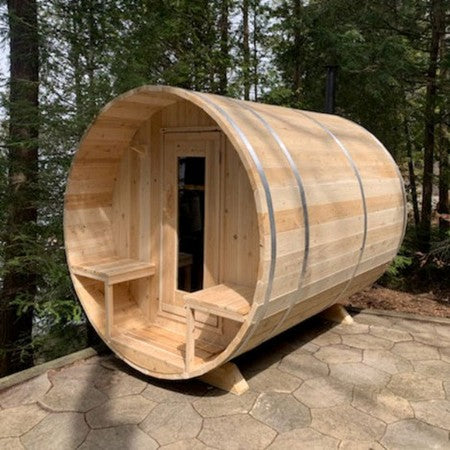 Wooden barrel-shaped sauna in a forest setting